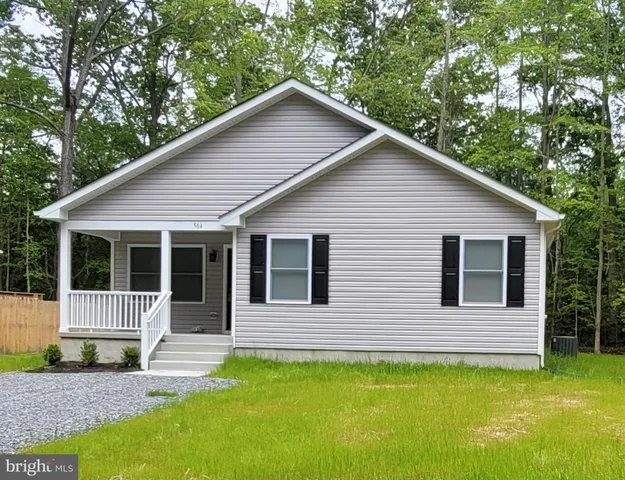 a view of a house with a yard balcony and wooden fence