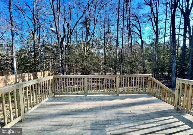 a view of a balcony with wooden floor and fence