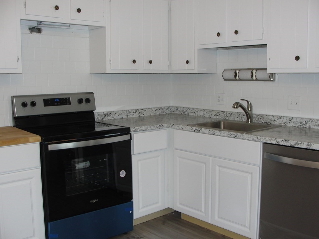318 Codman Hill Road, Unit 36E Boxborough, MA 01719 - Photo 5 of 18 a kitchen with granite countertop white cabinets and a stove