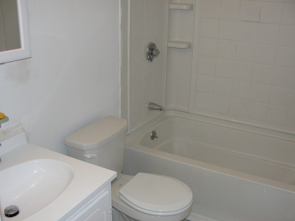 318 Codman Hill Road, Unit 36E Boxborough, MA 01719 - Photo 7 of 18 a white toilet and tub sitting next to a bathroom sink