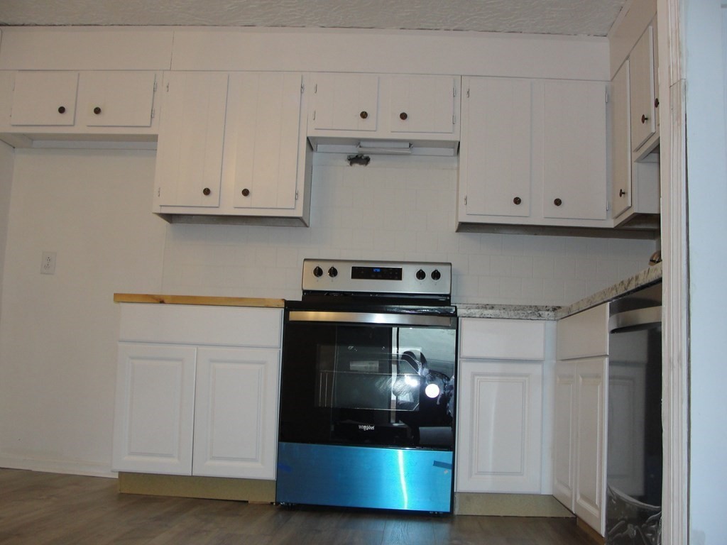 318 Codman Hill Road, Unit 36E Boxborough, MA 01719 - Photo 8 of 18 a kitchen with white cabinets and a stove