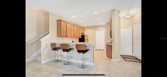 a kitchen with stainless steel appliances kitchen island granite countertop a refrigerator and cabinets