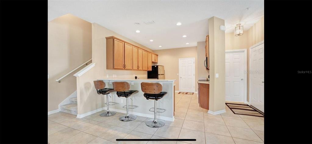 8174 Enchantment Drive, Unit 1601 Windermere, FL 34786 - Photo 8 of 21 a kitchen with stainless steel appliances kitchen island granite countertop a refrigerator and cabinets