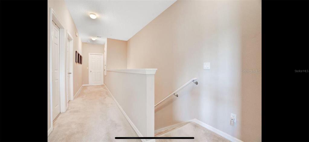 8174 Enchantment Drive, Unit 1601 Windermere, FL 34786 - Photo 9 of 21 a view of a hallway with white walls and stairs