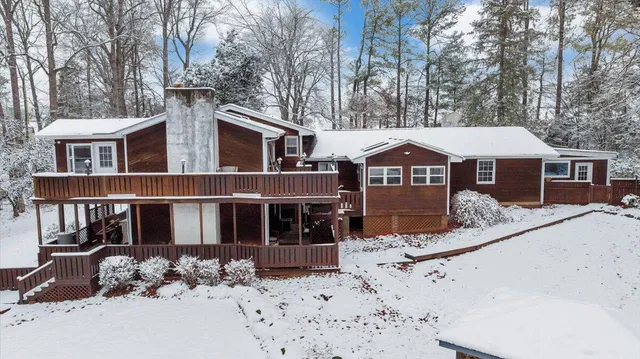 a front view of a house with a yard covered in snow