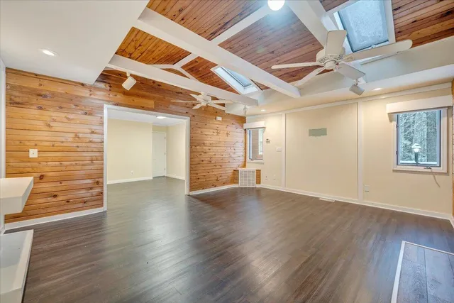 a view of a livingroom with a fireplace a chandelier and wooden floor