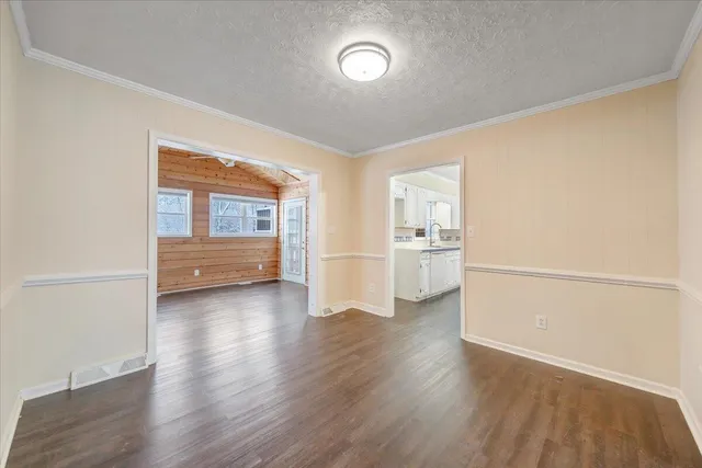 an empty room with wooden floor and a large window