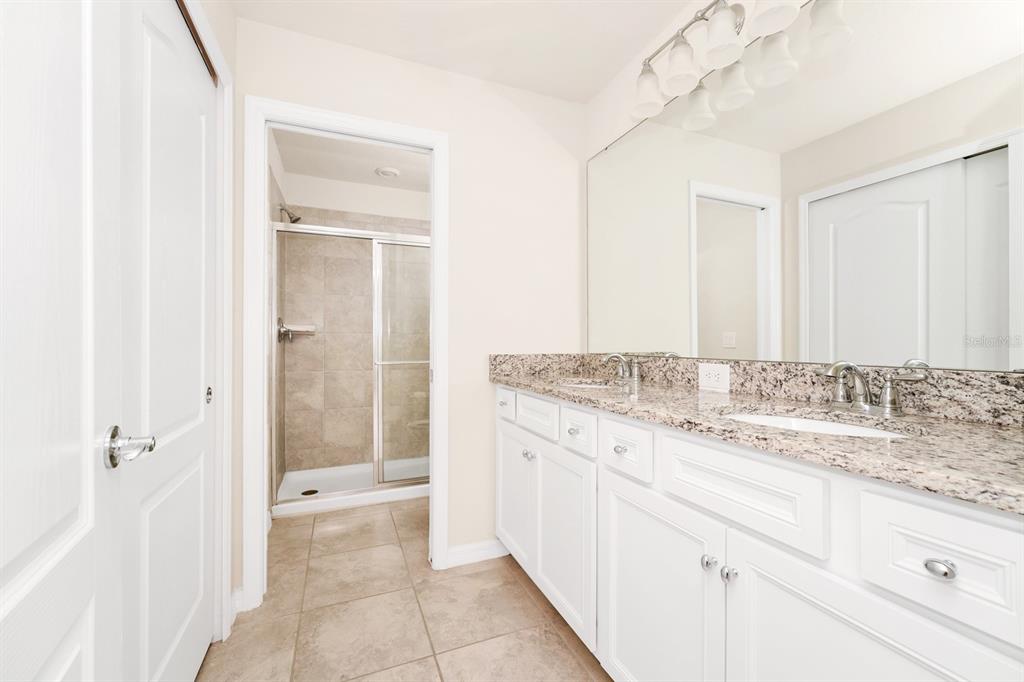 7513 Oak Spring Lane Davenport, FL 33837 - Photo 25 of 40 a bathroom with a granite countertop sink and a mirror