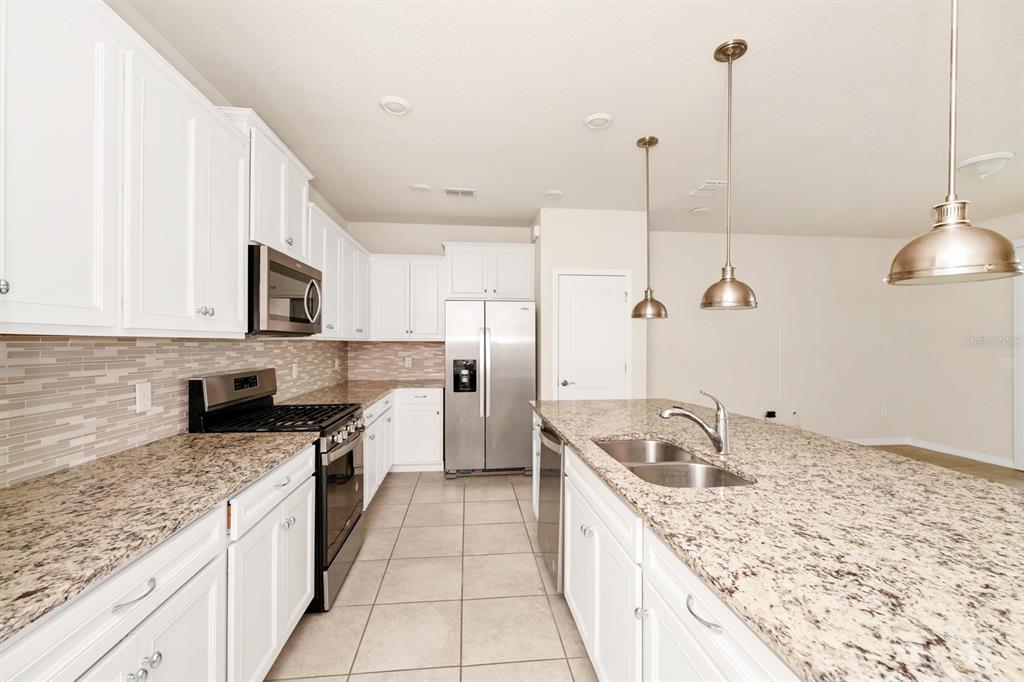 7513 Oak Spring Lane Davenport, FL 33837 - Photo 6 of 40 a kitchen with a sink stove and refrigerator