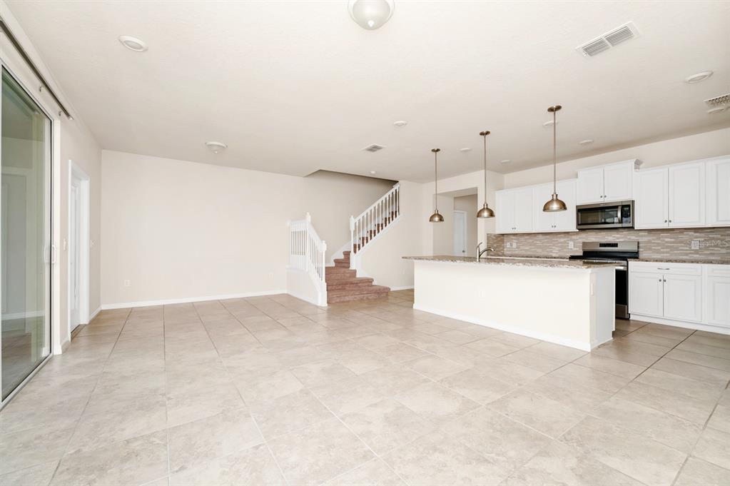 7513 Oak Spring Lane Davenport, FL 33837 - Photo 8 of 40 a view of kitchen with kitchen island white cabinets and stainless steel appliances