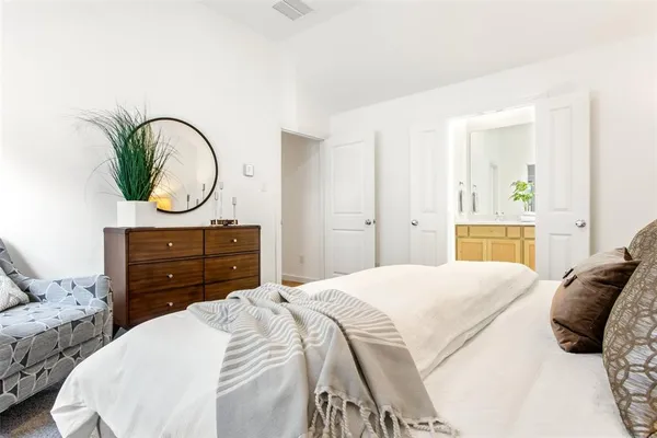 a bedroom with a bed a mirror and a window