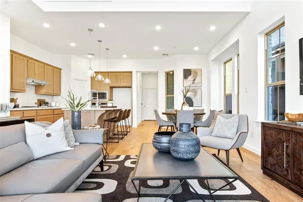 a living room with furniture kitchen view and large windows