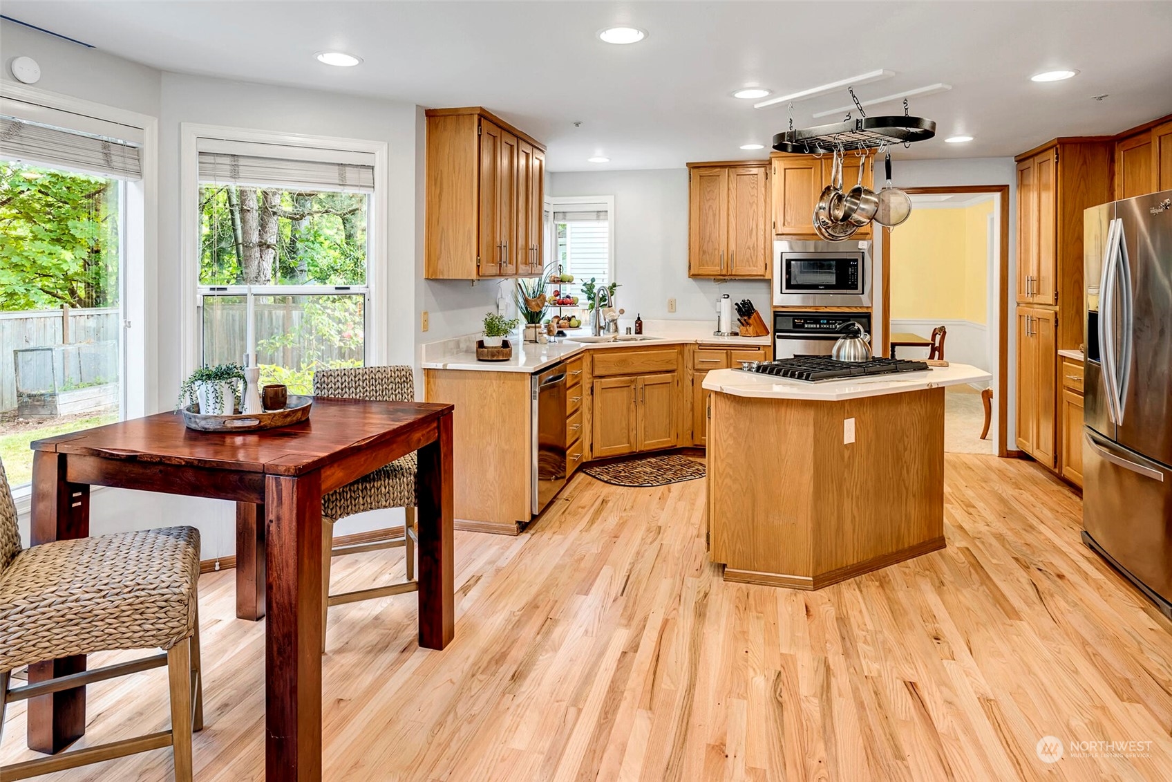 4516 Northeast 26th Court Renton, WA 98059 - Photo 8 of 28 a kitchen with stainless steel appliances kitchen island granite countertop wooden floors and sink