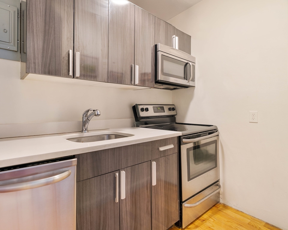 5 North Margin Street, Unit 5 Boston, MA 02113 - Photo 4 of 15 a utility room with stainless steel appliances white cabinets and a sink