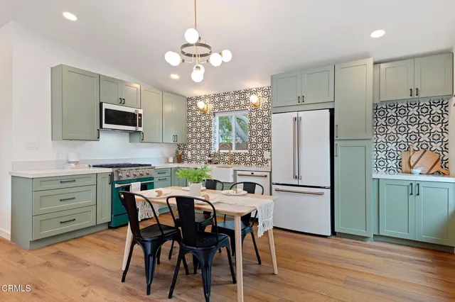 a kitchen with refrigerator a sink and chairs
