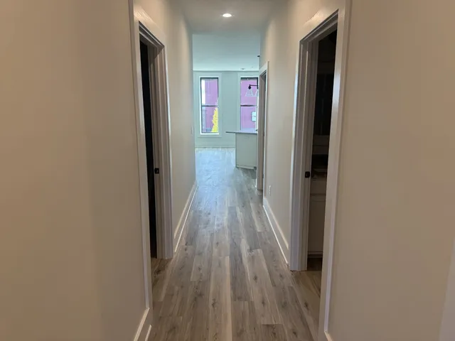 a view of a hallway with wooden floor