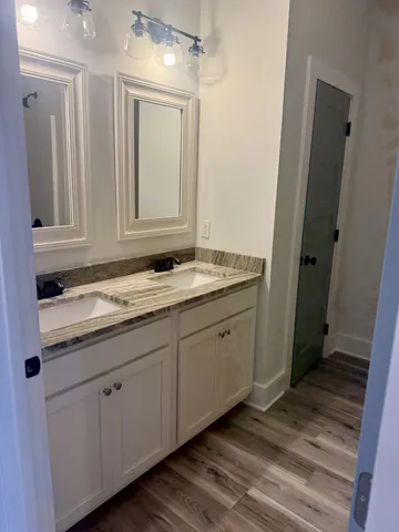 a bathroom with a granite countertop sink and mirror