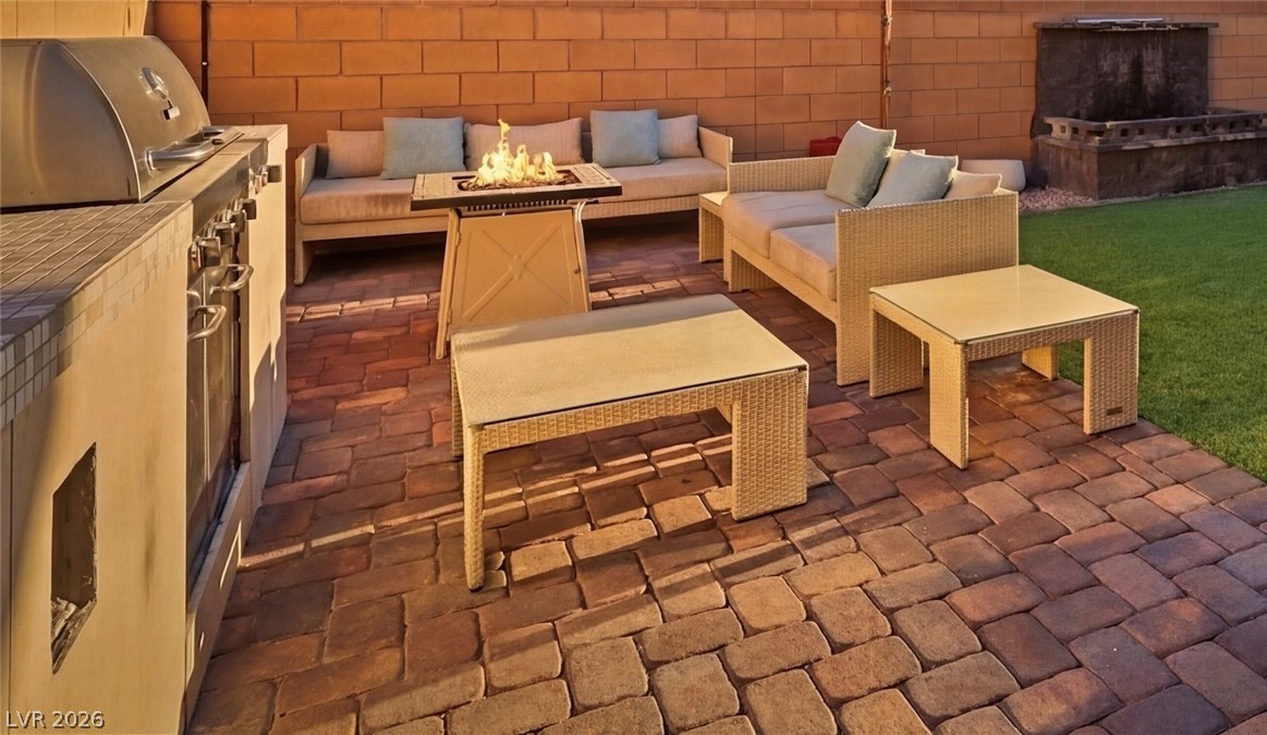 1921 Miller Ridge Avenue North Las Vegas, NV 89031 - Photo 24 of 26 An inviting outdoor living area features a built-in barbecue and a cozy fire pit.