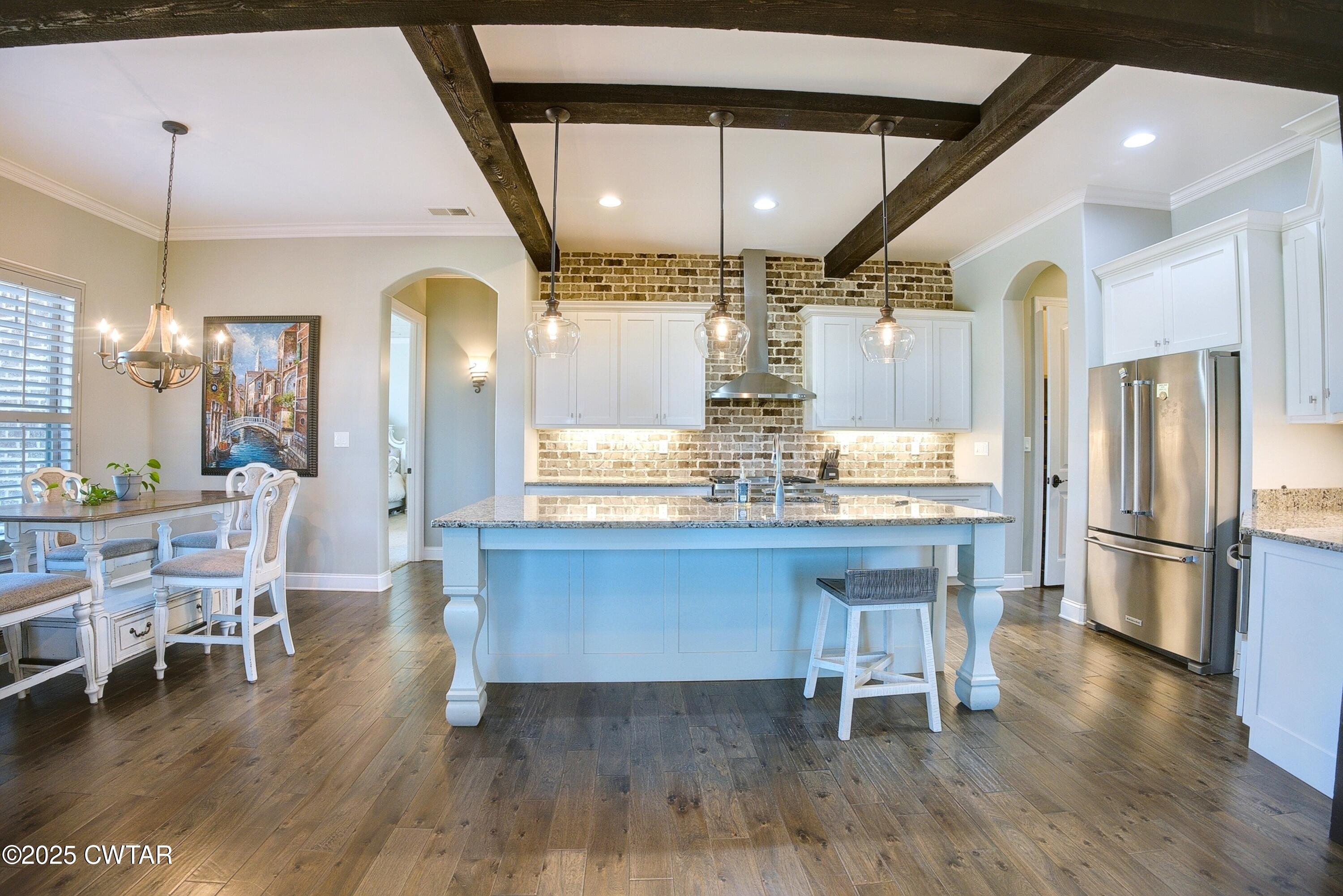 963 Ashport Road Jackson, TN 38305 - Photo 14 of 51 a kitchen with stainless steel appliances granite countertop a table chairs and a chandelier