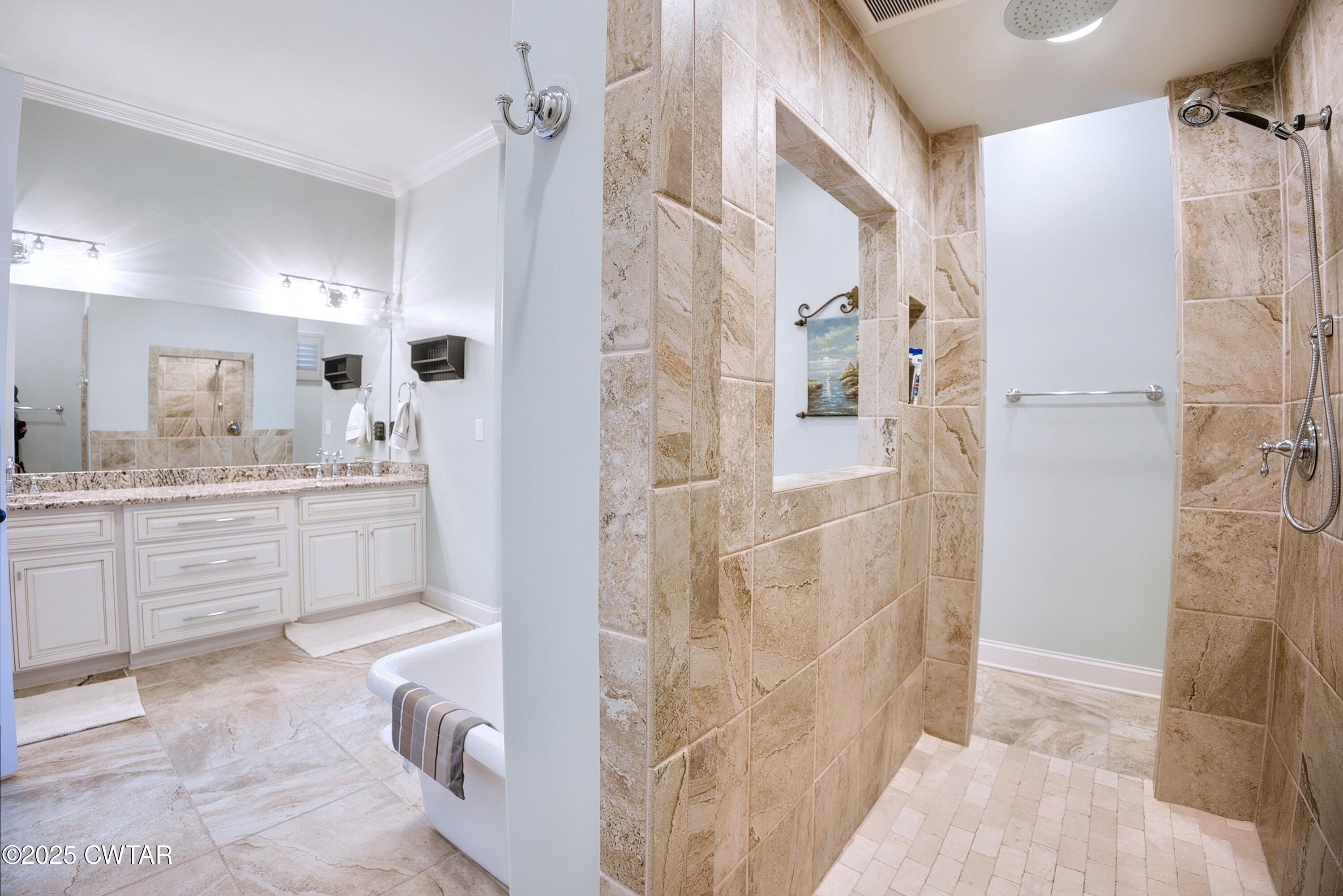 963 Ashport Road Jackson, TN 38305 - Photo 28 of 51 a bathroom with a double vanity sink a mirror a shower and a bathtub