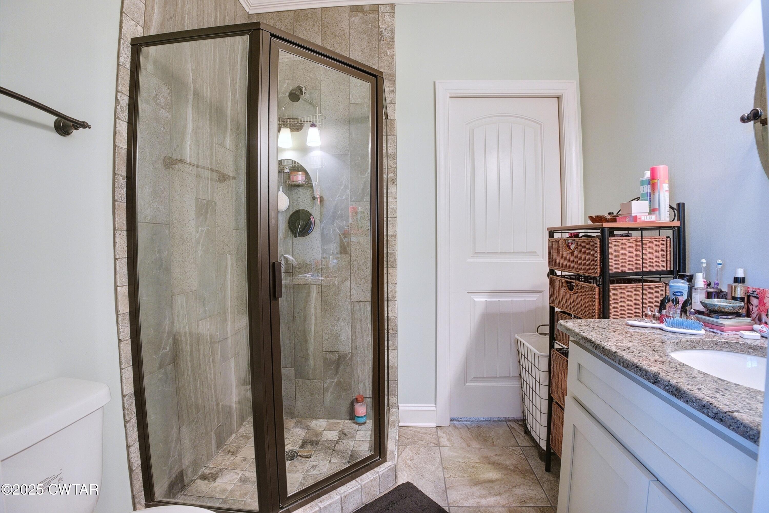 963 Ashport Road Jackson, TN 38305 - Photo 33 of 51 a bathroom with a granite countertop shower mirror and a sink