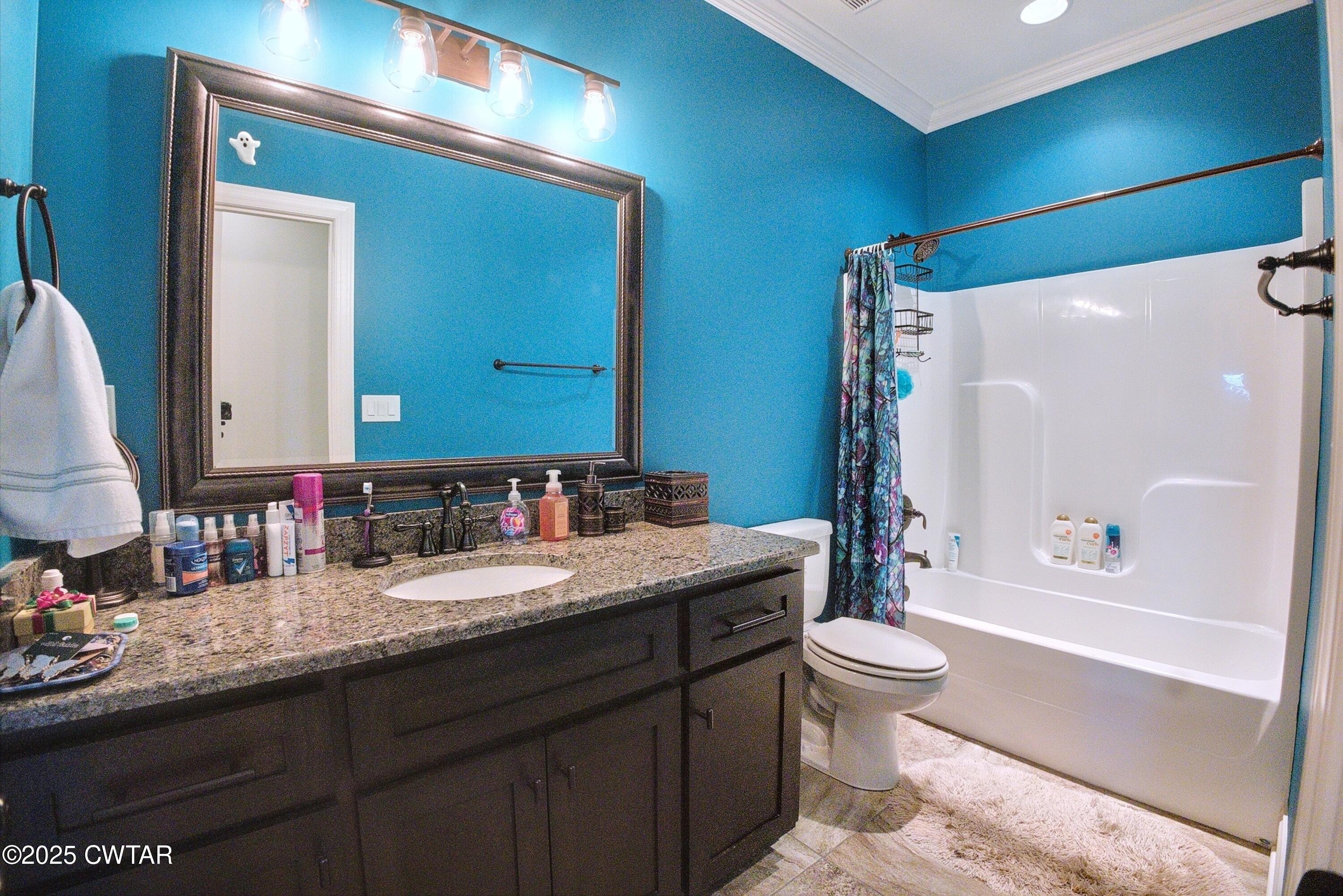 963 Ashport Road Jackson, TN 38305 - Photo 35 of 51 a bathroom with a granite countertop sink toilet mirror and bathtub
