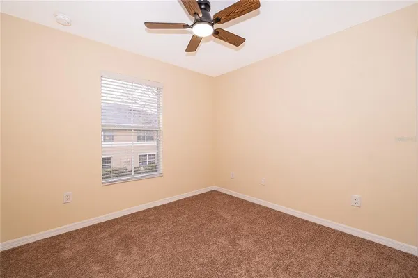 an empty room with a window and a fan