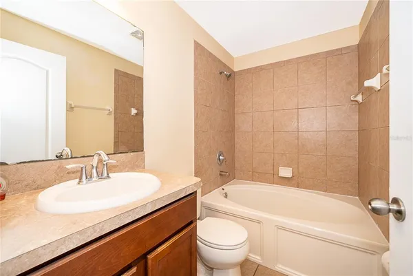 a bathroom with a granite countertop sink a toilet and bathtub