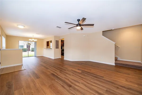 a view of a big room with wooden floor and a kitchen