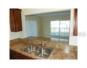a kitchen with granite countertop a sink and a stove top oven