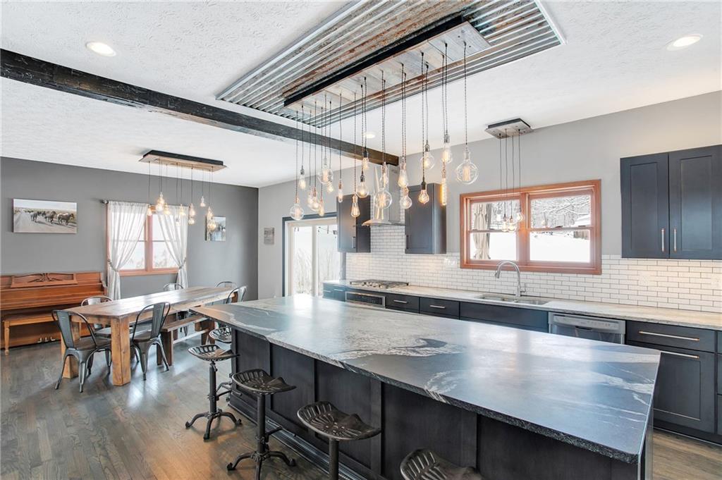 391 Bacon Run Road Clarksville, PA 15322 - Photo 11 of 25 There is bar-stool seating at the extended island with granite countertops and industrial lighting fixture. Subway tile backsplash wraps around the kitchen.
