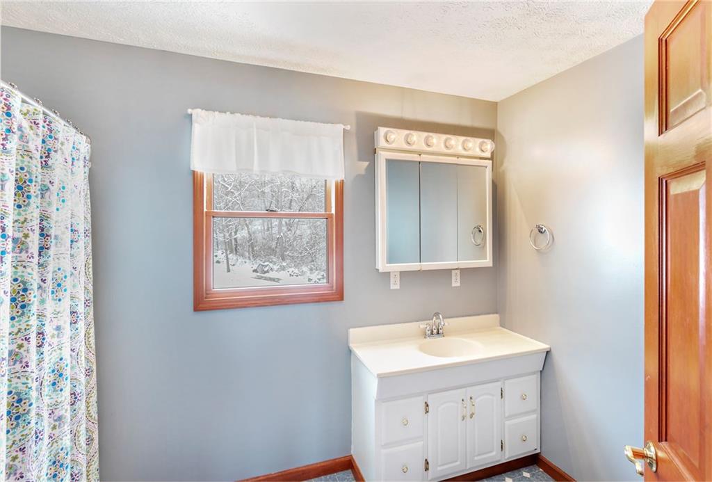 391 Bacon Run Road Clarksville, PA 15322 - Photo 18 of 25 2nd bathroom features natural lighting, oversized white vanity, and window overlooking the wooded backyard.