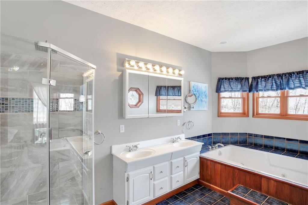 391 Bacon Run Road Clarksville, PA 15322 - Photo 20 of 25 Master bath features walk in, glass shower with accent blue tiling, his and her sinks, and an oversized tub.