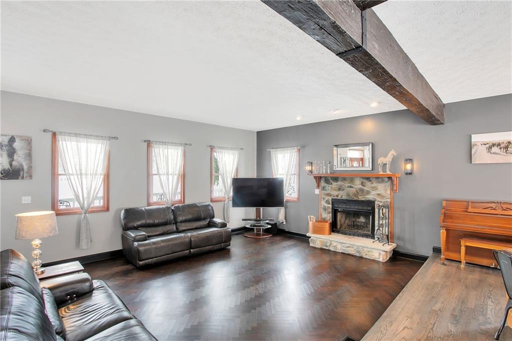 391 Bacon Run Road Clarksville, PA 15322 - Photo 9 of 25 Open floor plan with stone fireplace and decorative wood beam.
