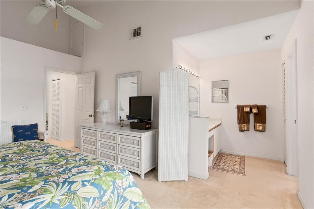 81 Emerald Woods Drive, Unit M8 Naples, FL 34108 - Photo 11 of 18 a bedroom with a bed and a television