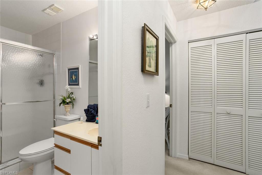 81 Emerald Woods Drive, Unit M8 Naples, FL 34108 - Photo 13 of 18 a white toilet sitting next to a bathroom sink and vanity