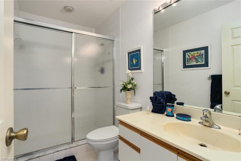 81 Emerald Woods Drive, Unit M8 Naples, FL 34108 - Photo 14 of 18 a bathroom with a sink toilet and shower