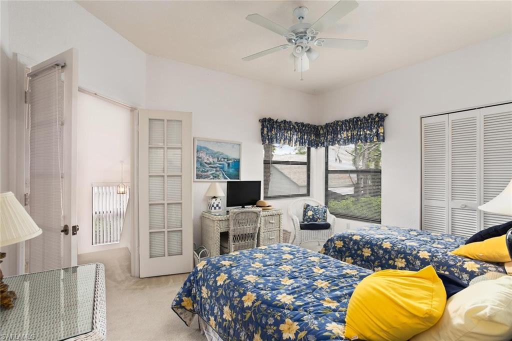 81 Emerald Woods Drive, Unit M8 Naples, FL 34108 - Photo 15 of 18 a bedroom with a bed a ceiling fan and a window