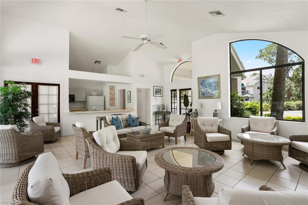 81 Emerald Woods Drive, Unit M8 Naples, FL 34108 - Photo 17 of 18 a living room with furniture a rug and a large window