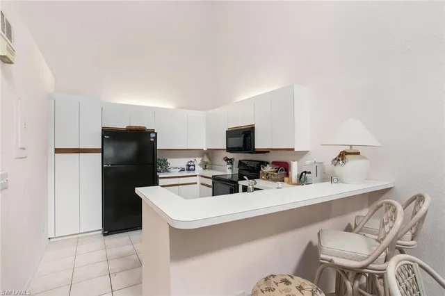 a kitchen with a sink a counter appliances and cabinets