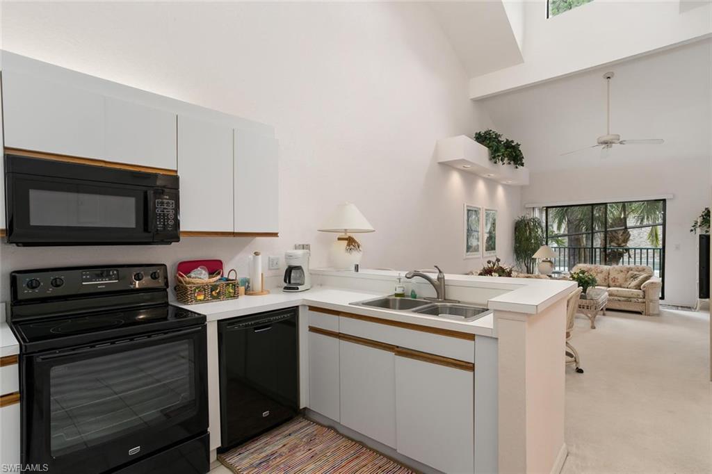 81 Emerald Woods Drive, Unit M8 Naples, FL 34108 - Photo 9 of 18 a kitchen with a sink stove and microwave