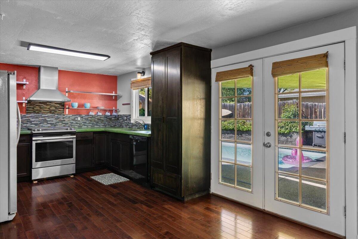 113 Houston Road Phoenix, OR 97535 - Photo 12 of 29 a kitchen with stainless steel appliances granite countertop a refrigerator a stove and a wooden floors