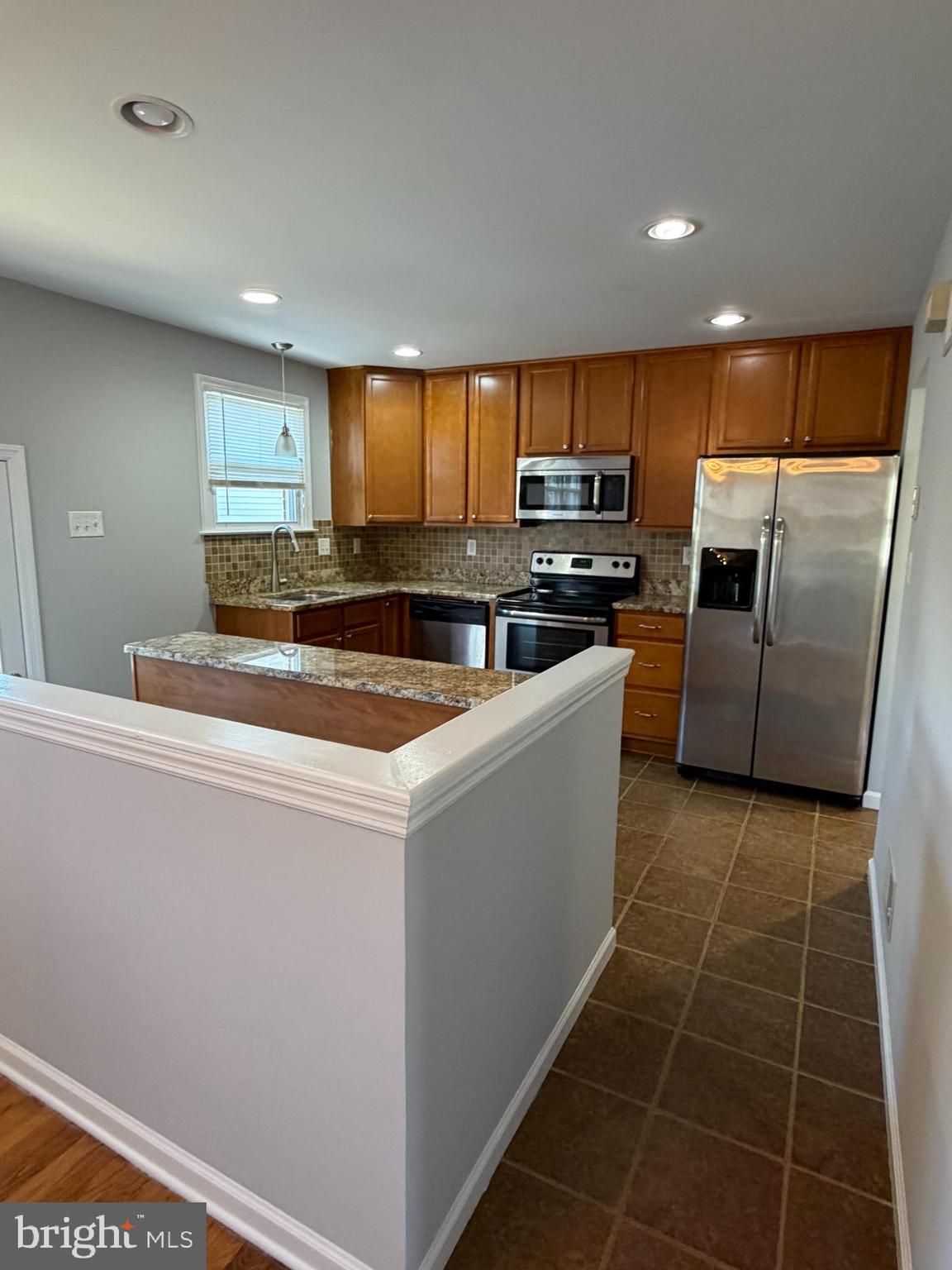 2630 Millcreek Road Wilmington, DE 19808 - Photo 8 of 26 a kitchen with stainless steel appliances granite countertop a sink a stove a refrigerator a microwave with white cabinets and a window