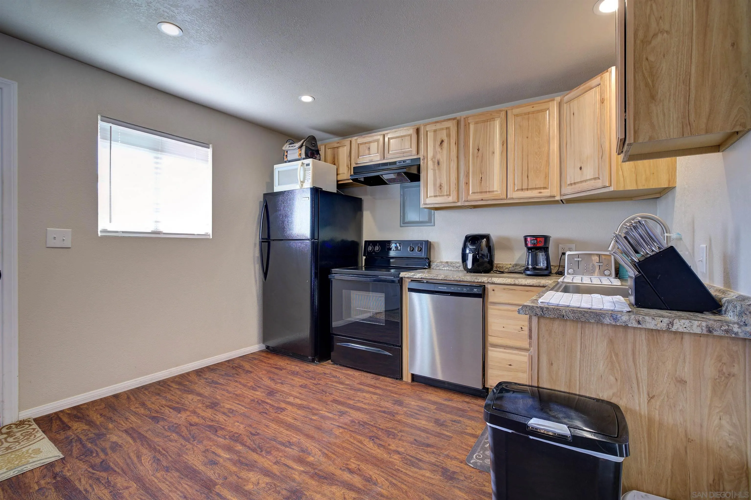 15835 Mactan Road Valley Center, CA 92082 - Photo 25 of 31 a kitchen with stainless steel appliances granite countertop a refrigerator sink and cabinets