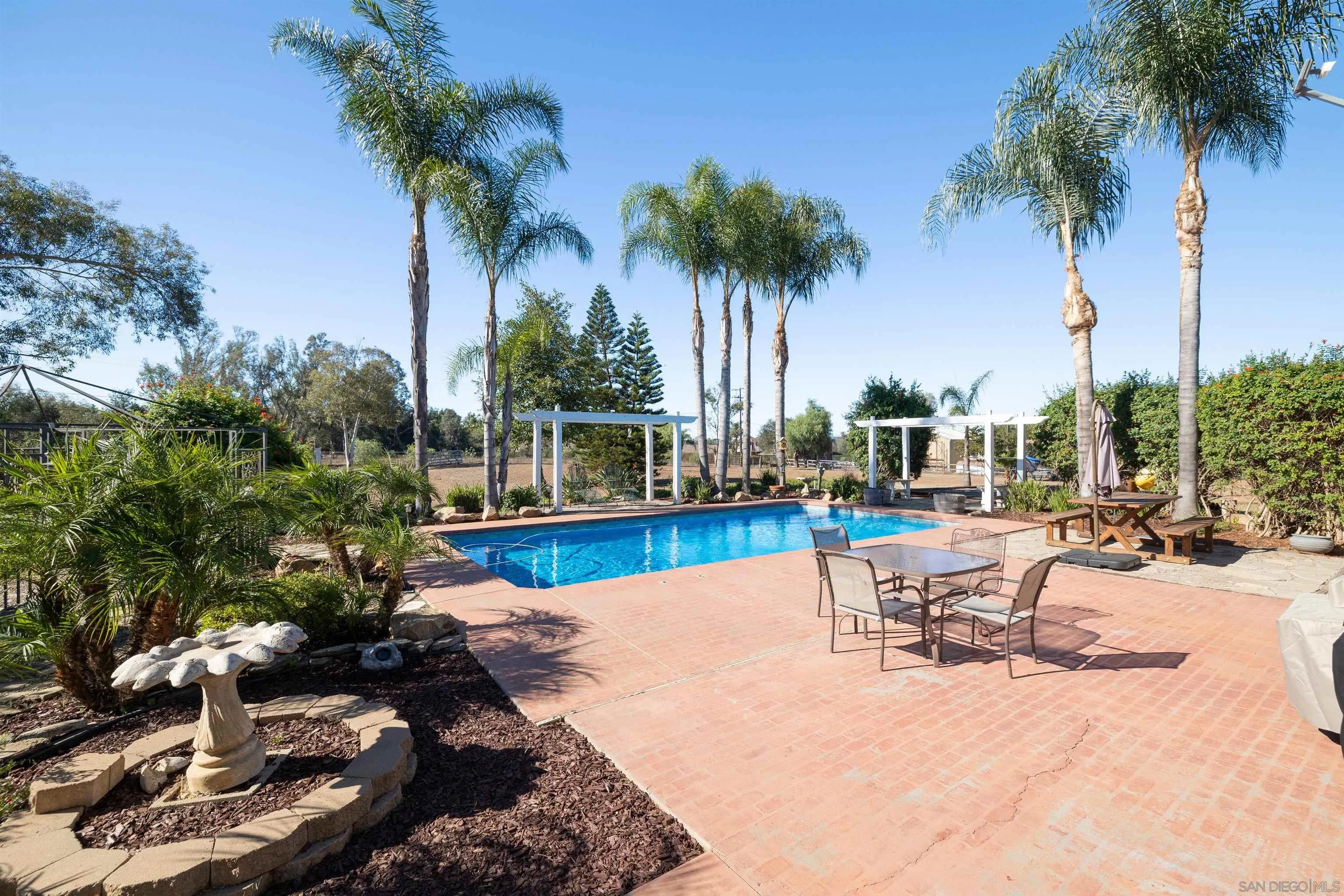 15835 Mactan Road Valley Center, CA 92082 - Photo 28 of 31 a view of a swimming pool with a table and chairs