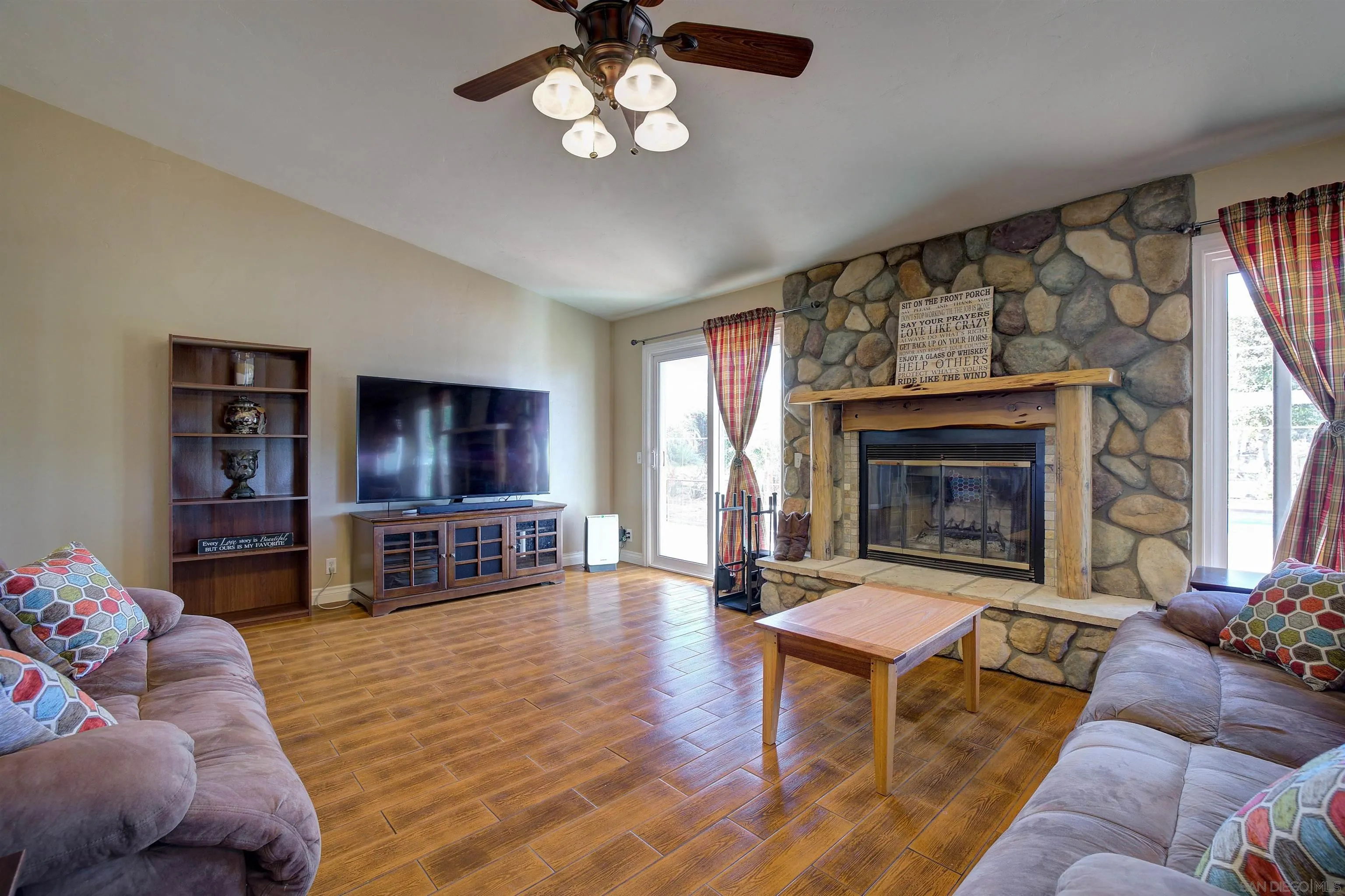 15835 Mactan Road Valley Center, CA 92082 - Photo 7 of 31 a living room with furniture a flat screen tv and a fireplace
