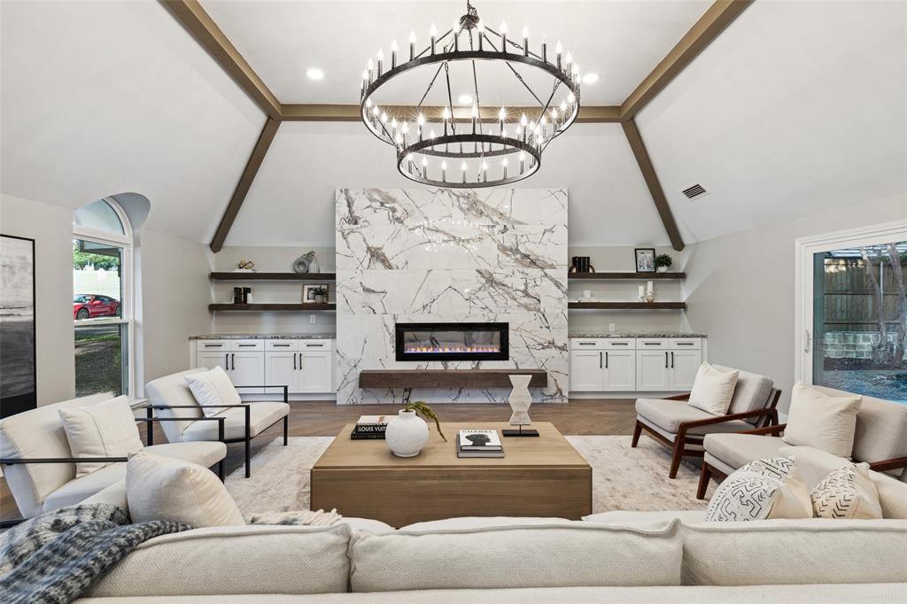 a living room with furniture a fireplace and a chandelier