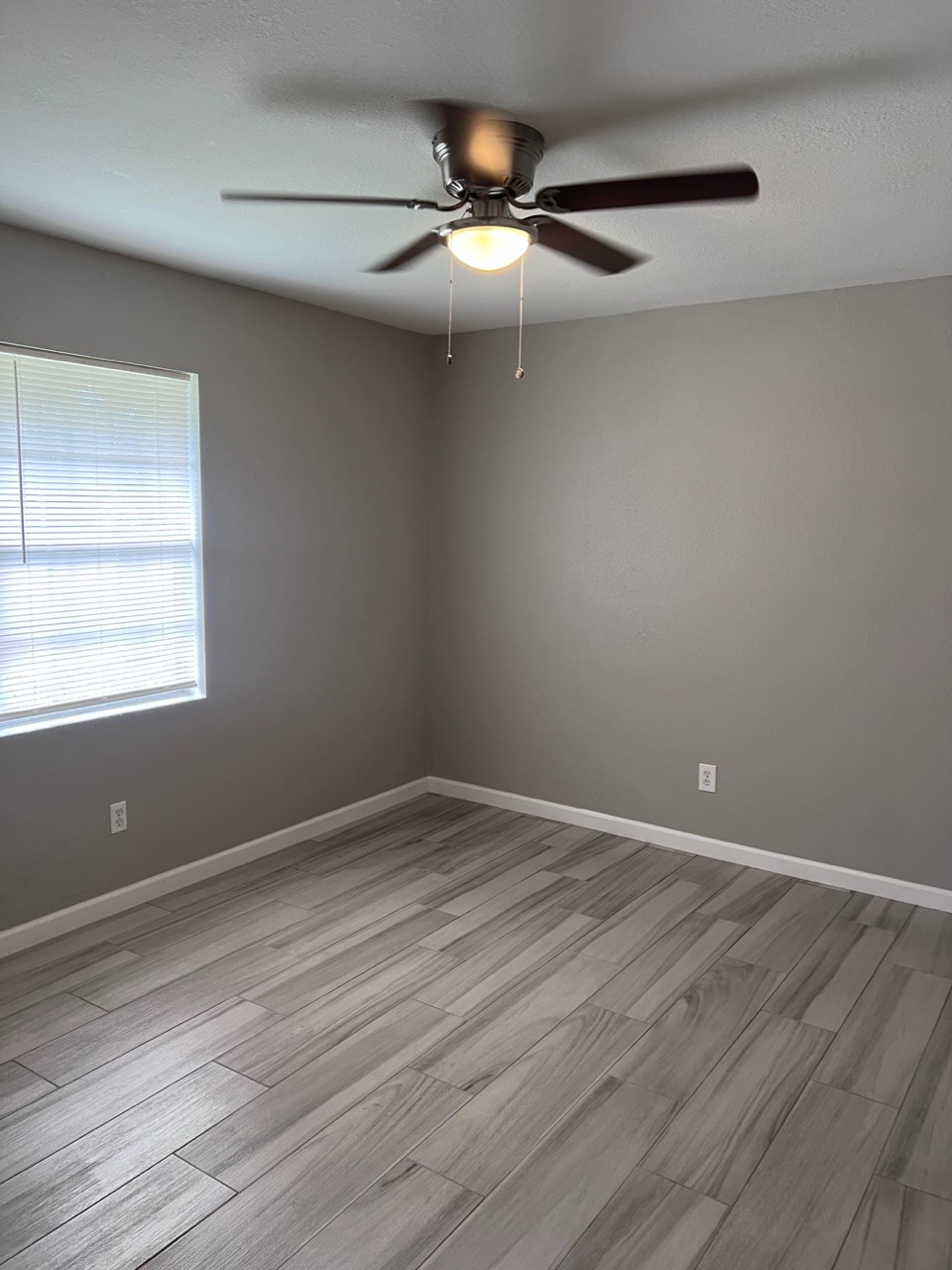 503 Park Lane, Unit 1 Cleveland, TX 77327 - Photo 7 of 9 a view of an empty room with wooden floor and a window