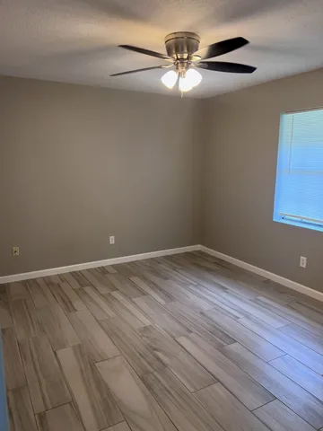 a view of an empty room with wooden floor