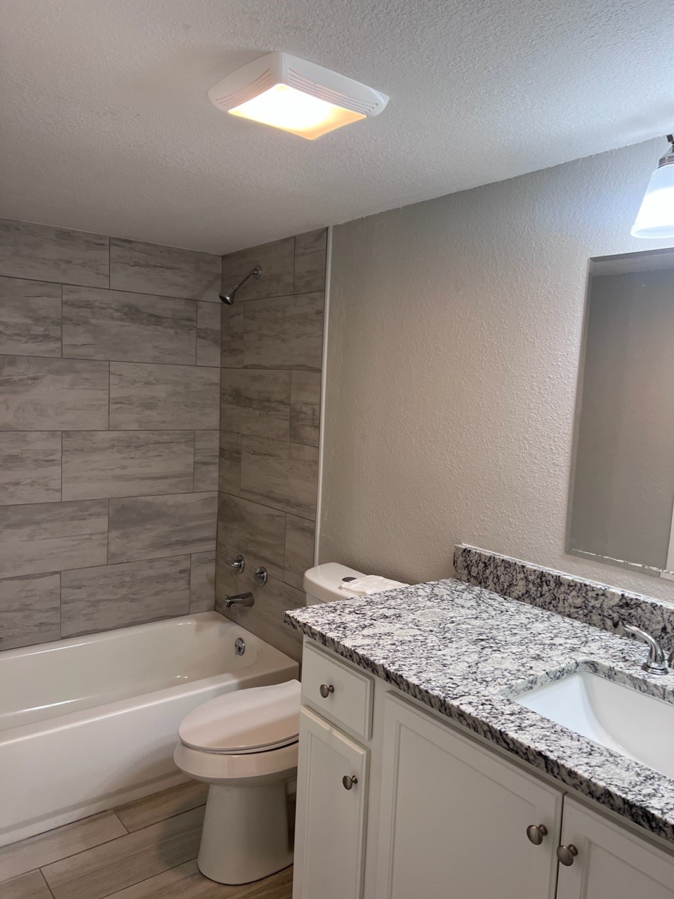 503 Park Lane, Unit 1 Cleveland, TX 77327 - Photo 9 of 9 a bathroom with a granite countertop sink a toilet and bathtub